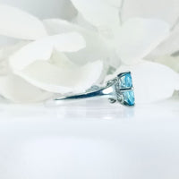 Perspective view of the Celeste Azure ring highlighting the oval blue Topaz gemstone and elegant design