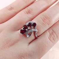 showcasing the intricate silver details and the elegant swirling pattern of garnet gemstones