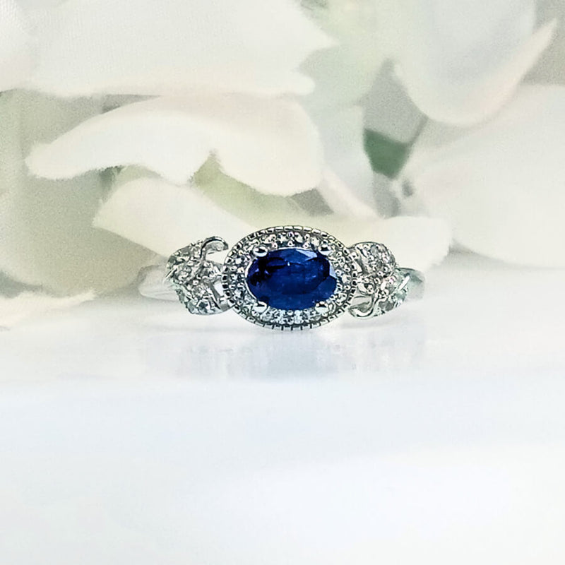 Front view of Women's Royal Deep Sea Blue Sapphire Ring in 925 Sterling Silver featuring a petite beautiful blue sapphire gem in a sleek, intricate royal design 
